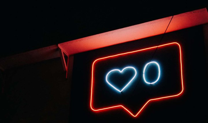 Neon sign showing a speech bubble sign with a love heart and the number zero
