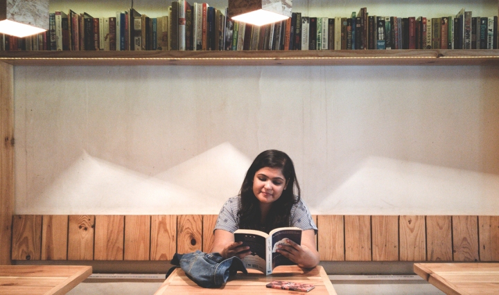 An Indian woman is reading in a library